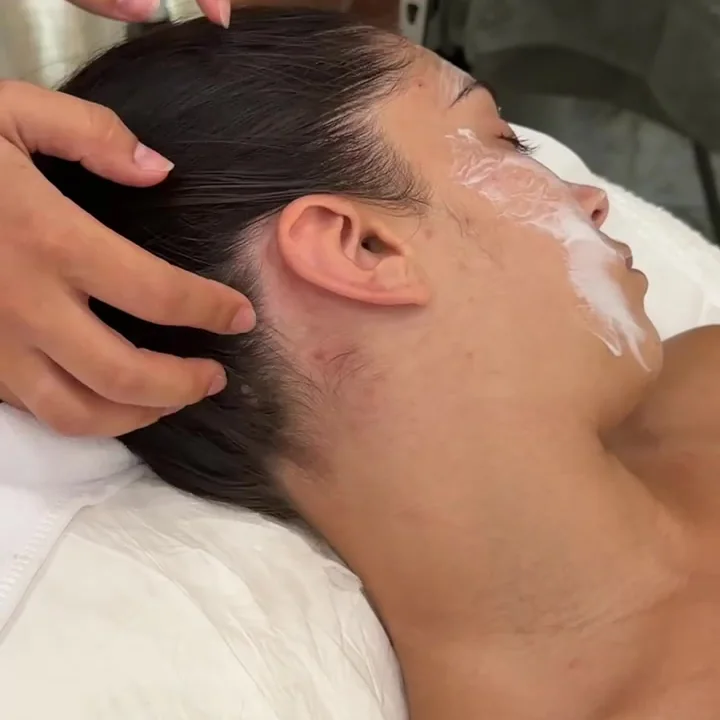 Modelage du visage a deux mains pendant un soin, en cabine